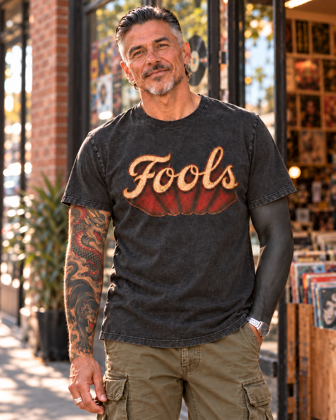 Close-up of the FOOLS Dive Bar Tee with a slicked-back hairstyle and tattoo sleeves.