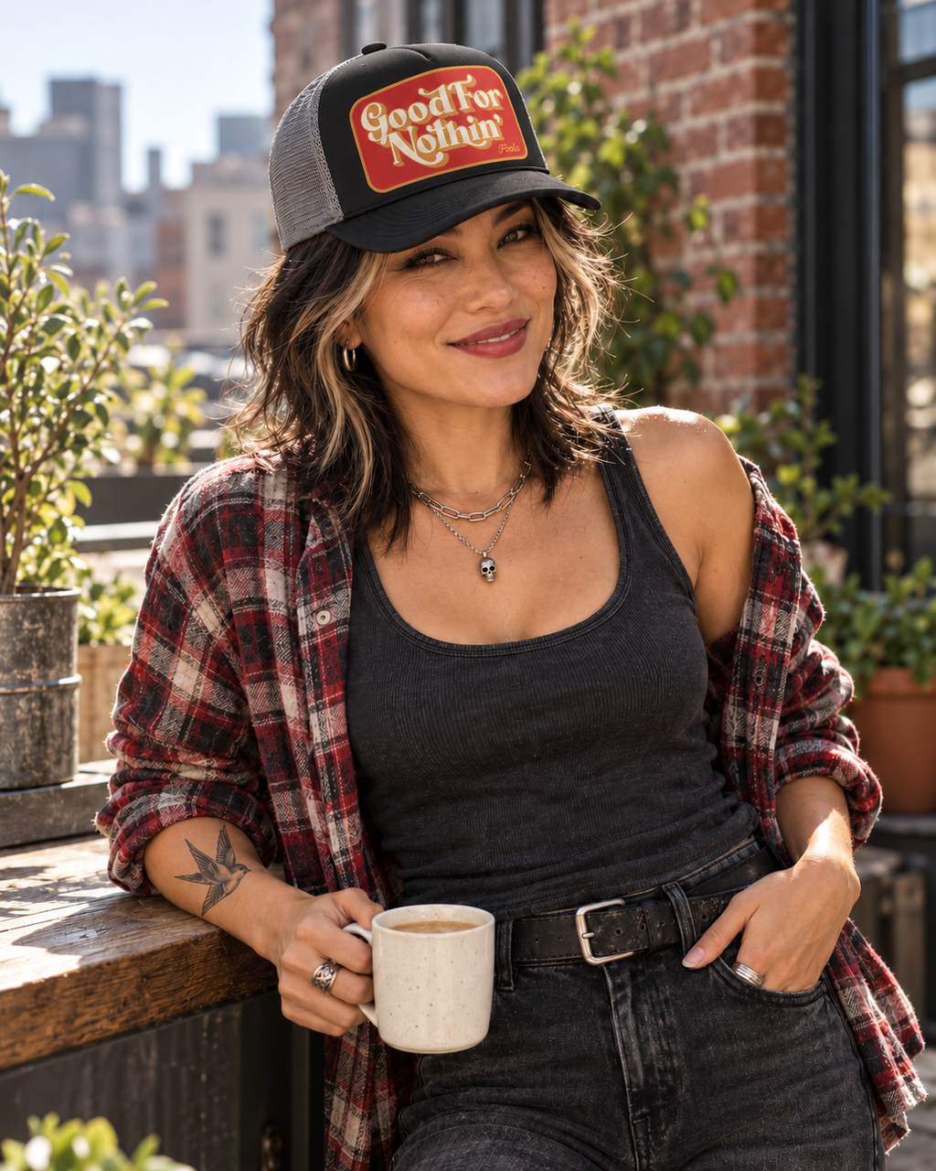 FOOLS Good For Nothin black foam and gray mesh trucker hat styled with vintage flannel, charcoal tank and silver skull necklace over morning coffee.