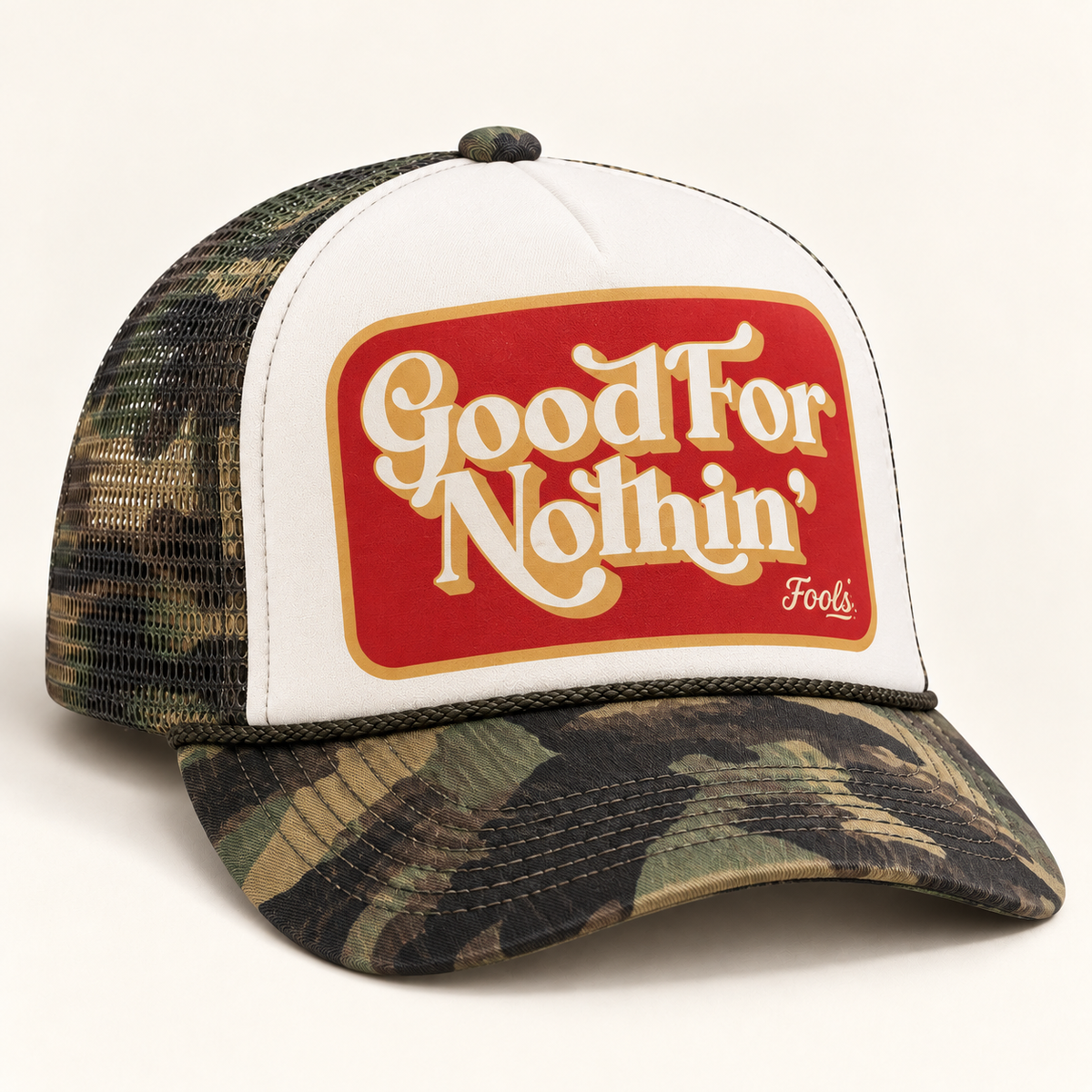 FOOLS Good For Nothin trucker hat with white foam front, camouflage mesh and bill, and red and cream retro graphic.