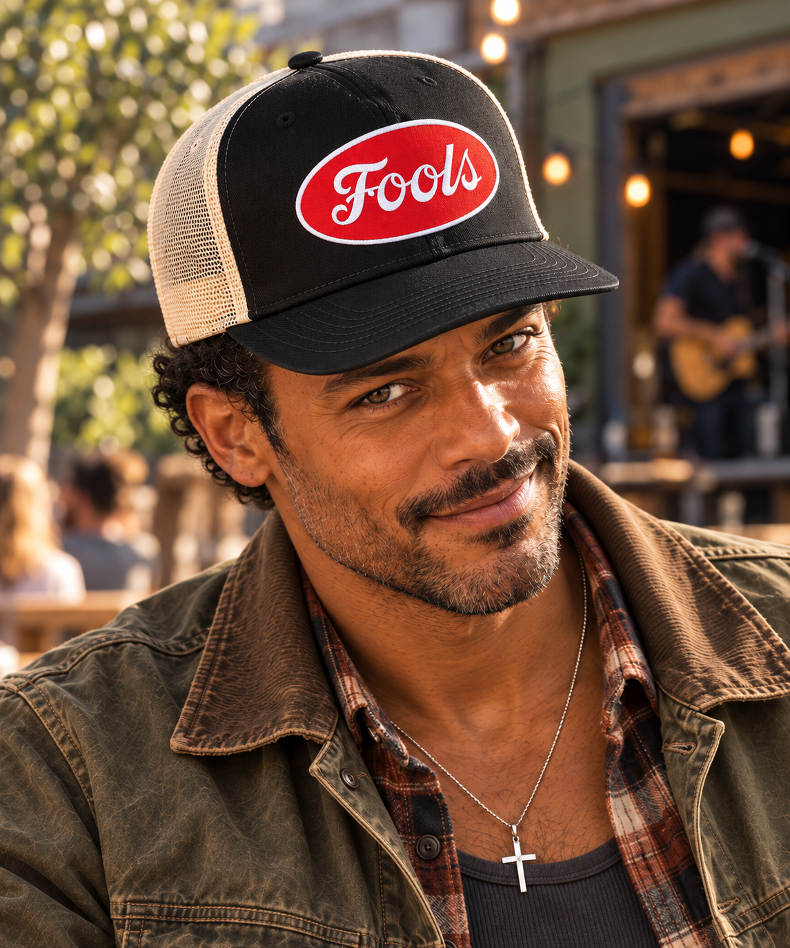 Close-up of the FOOLS Good Times Snap Back with black twill front, ecru mesh and red oval FOOLS patch, worn with vintage workwear.