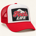 FOOLS Life Beer red mesh and bill with white foam-front trucker hat, featuring flat red Fools LIFE mountain artwork.