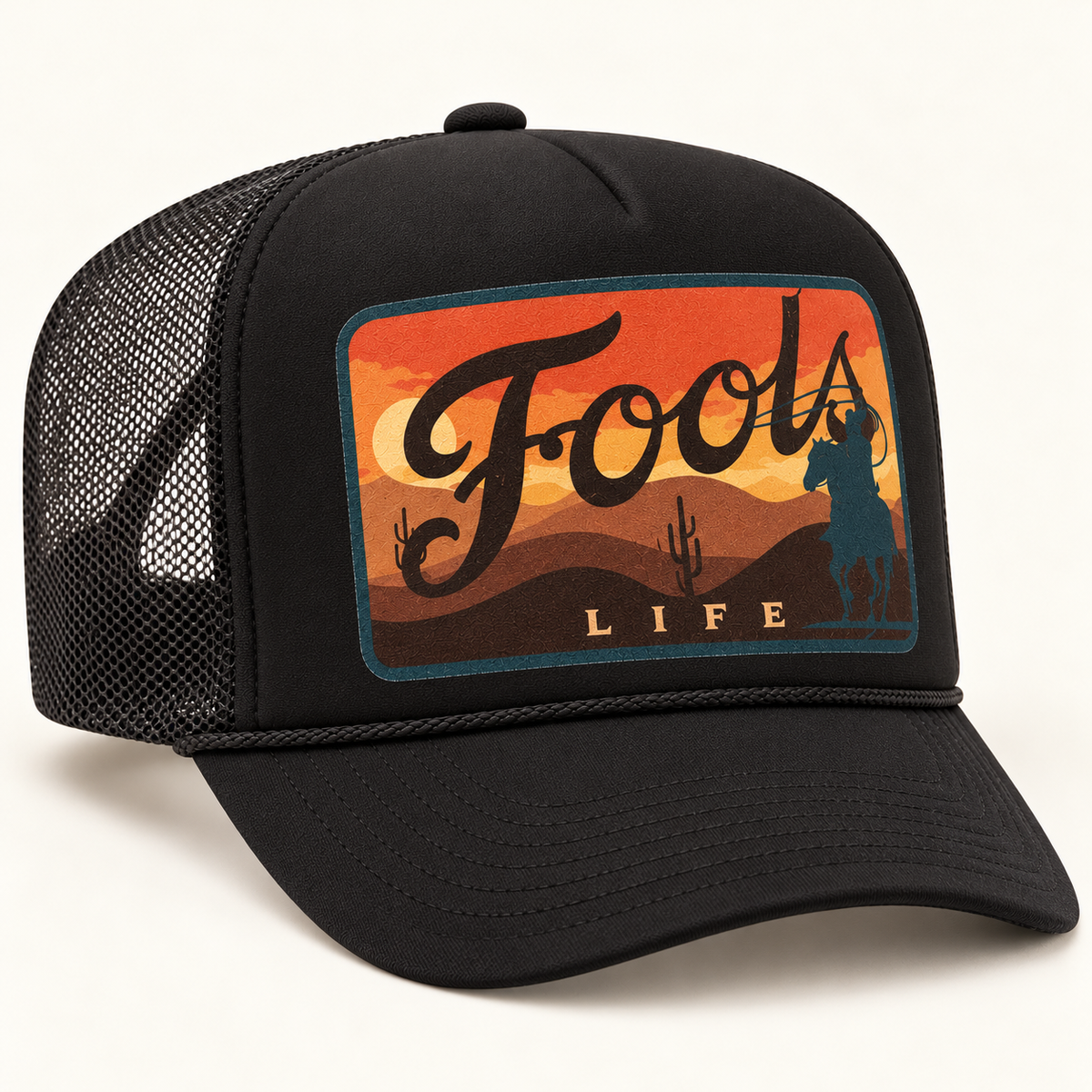 FOOLS Life Lasso all-black foam-front mesh trucker hat with flat sunset cowboy artwork and black curved bill.