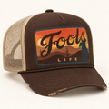 FOOLS Life Lasso brown foam-front and beige mesh trucker hat with flat sunset cowboy artwork and vintage worn bill.