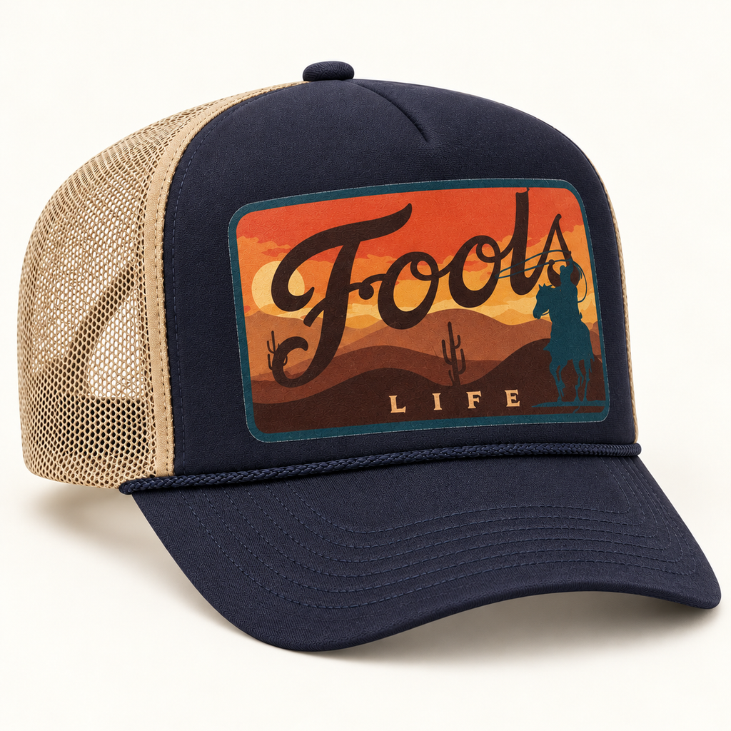 FOOLS Life Lasso navy foam-front and beige mesh trucker hat with flat sunset cowboy artwork and navy curved bill.