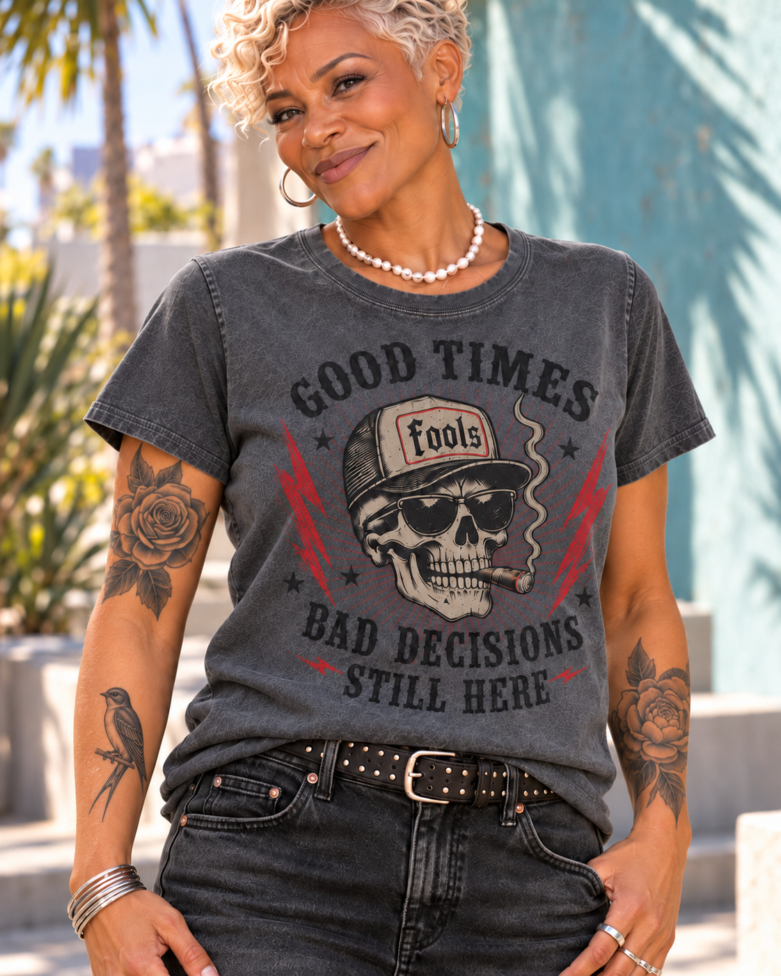 Close-up of the FOOLS Women's Still Here Faded Tee in faded coal, showing the black-lettered skull graphic, pearl necklace and corrected resting-bird tattoo